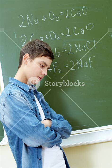 Sad Guy Standing By The Blackboard With Chemical Formulae On It Royalty