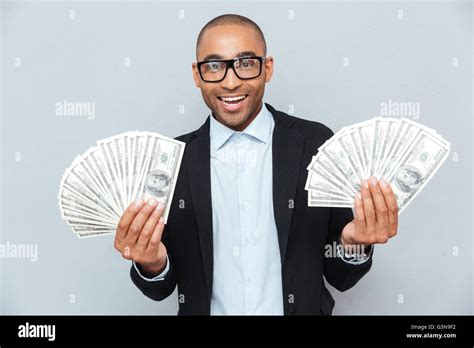 Smiling Successful African Young Man Holding A Lot Of Money In Both