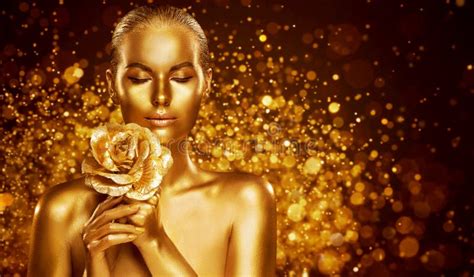 Golden Woman Beauty Fashion Model Girl With Golden Skin Makeup Hair And Jewellery On Gold
