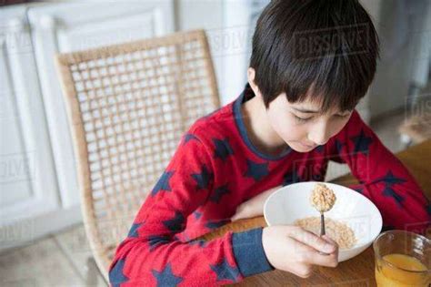 Boy Eating Breakfast Cereal At Table Stock Photo Dissolve