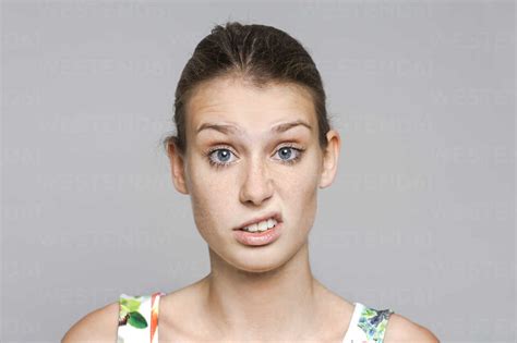 Portrait Of Young Woman Pouting Mouth In Front Of Grey Background Stock