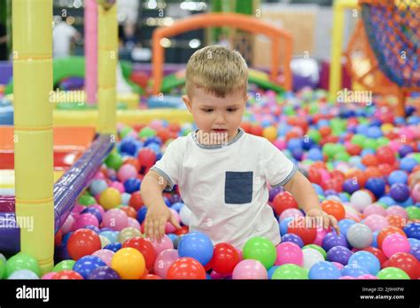A Boy In A Dry Paddling Pool In Playing Centre With Plastic Balls Stock