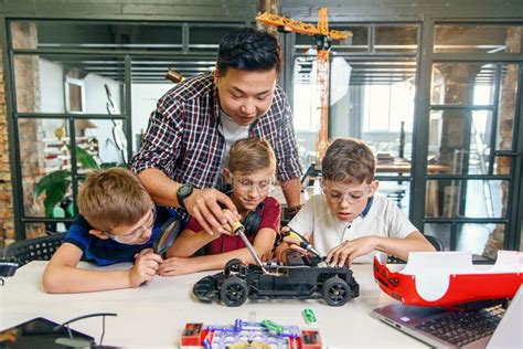 Electronic Engineer With European School Children Working In Modern