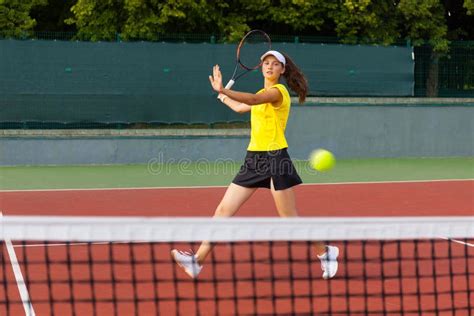 Professional Equipped Female Tennis Player Beating Hard The Tennis Ball With Racquet Stock