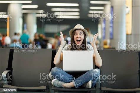 Young Shocked Traveler Tourist Woman With Laptop With Crossed Legs Spreading Hands Waiting In