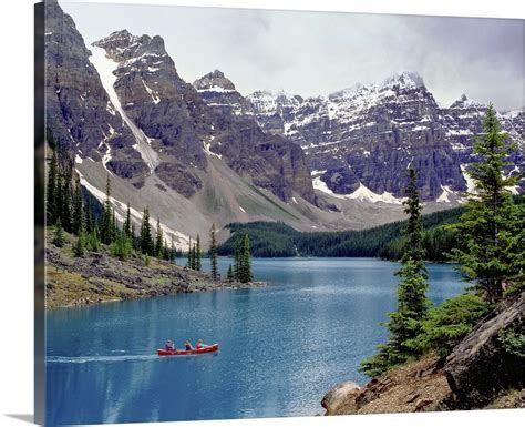 Canada Alberta A Canoe Glides Across Moraine Lake In The Valley Of