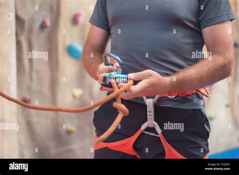 Rock Wall Climber Wearing Safety Harness And Climbing Equipment Indoor