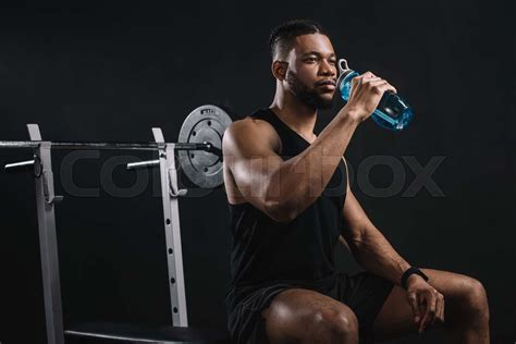 Muscular Young African American Sportsman Drinking Water From Bottle On