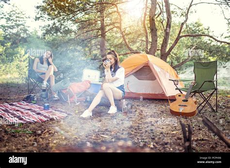 Party Camping Of Women At Forest They Relaxing Singing A Song And Cooking Barbecue Stock