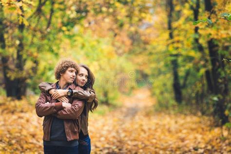 Curly Haired Mustachioed Guy And An Ore Haired Girl In Autumn Stand