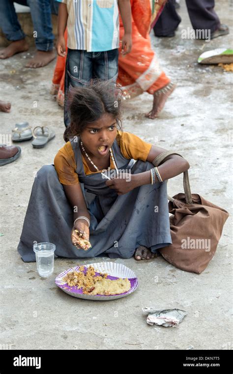 Poor Indian Lower Caste Girl Eating Free Food On An Indian Street Stock