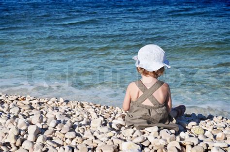 Lille pige der sad på stranden Stock foto Colourbox