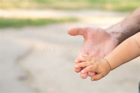 A Parent Father Holds The Hand Of A Small Child Copy Space Stock Photo