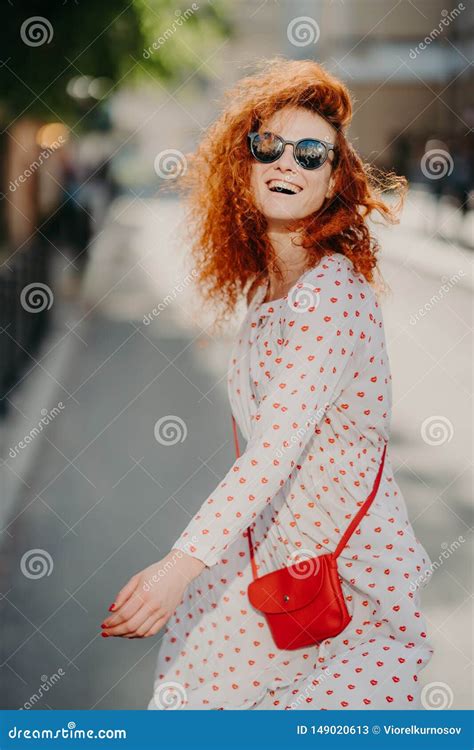 Happy Carefree Redhead Woman Laughs Positively Spends Free Time Outdoor In City Wears