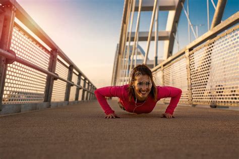 Beautiful Young Woman Doing Push Ups Outside On A Bridge Stock Image