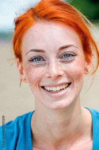 Portrait Of A Happy Smiling Beautiful Young Redhead Woman With Blue