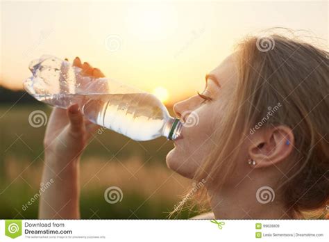 Female Athlete Being Thirsty After Running Holding Plastic Bottle