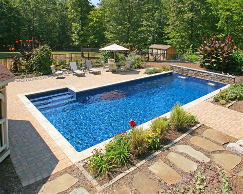 Timeless custom rectangle swimming pool with blue stone coping and hand cut stacked stone raised spa and walls. Inground Pools - Rideau Pools