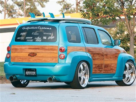 A Blue Minivan With Wood Trim Parked In Front Of A Building