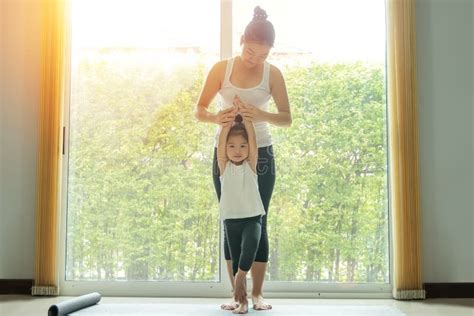 Mamá Asiática Practica Yoga Con Una Adorable Hija En Casa Trata De