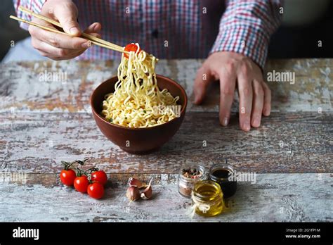 Male Hands Are Eating Chinese Noodles With Chopsticks Chinese Style