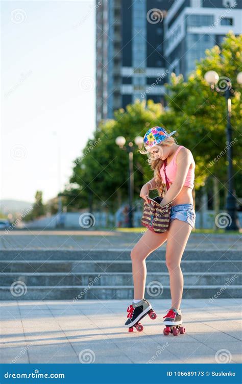 Young Blond Girl Skating On Vintage Rollers Down The Street Stock Image