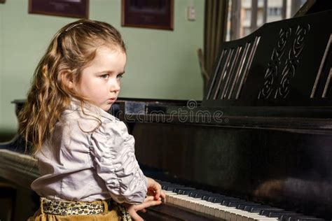 Cute Little Girl Playing Grand Piano In Music School Stock Image