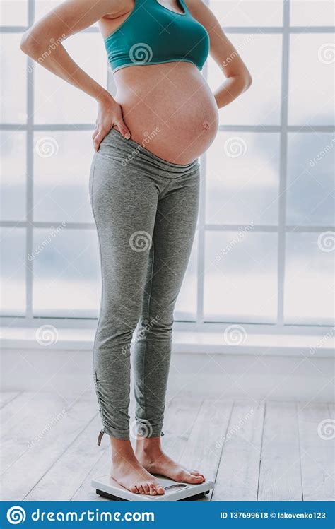 Cute Pregnant Woman Standing On Scales In Cozy Living Room Stock Photo Image Of Home Mother