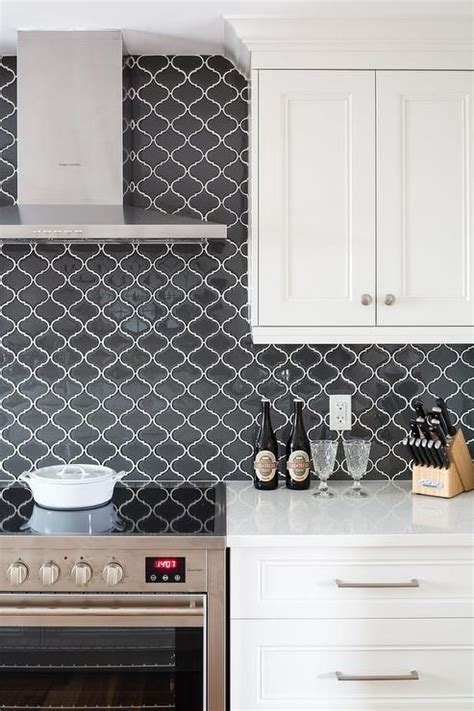 The shine reflected by glass backsplash tile can make your room feel more open and airy with light bouncing around the enchanting kitchen you've designed. Black arabesque backsplash tiles are a major key feature ...