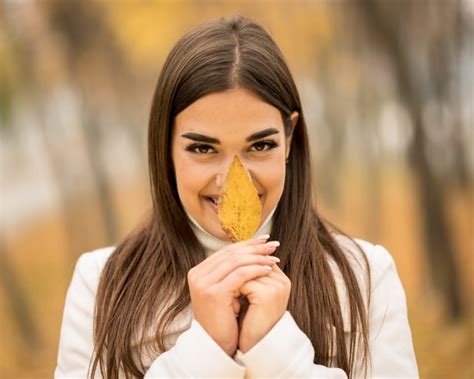 Free Photo Caucasian Attractive Woman Smiling And Holding A Fallen Leaf In The Fall