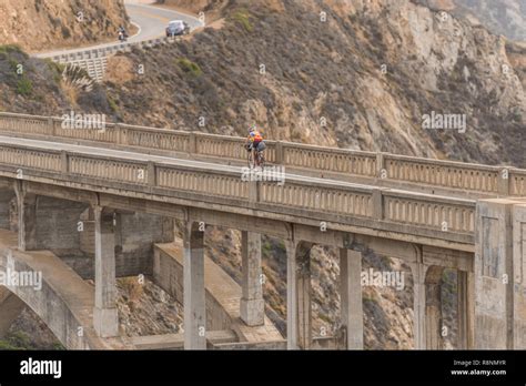 Cyclist Over The Bixby Creek Bridge At Sunset In Big Sur California