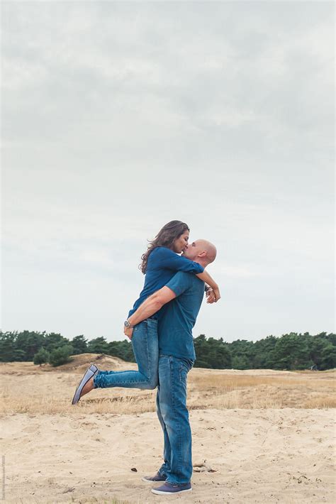 Man Picking Woman Up From The Ground For A Kiss By Stocksy Contributor Cindy Prins Stocksy