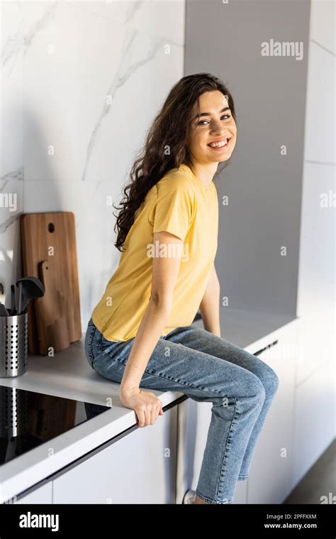 Young Woman Sitting On The Kitchens Counter Stock Photo Alamy