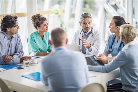 Team Of Doctors And Business People Talking On A Meeting At Doctors