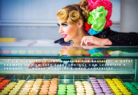 A Woman With Colorful Hair And Makeup Next To A Display Of Macaroni And