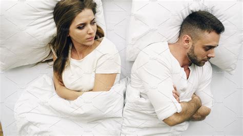 Top View Of Young Upset Couple Lying In Bed Have Problems After Quarrel
