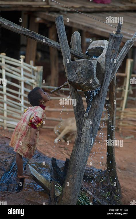 Girl Drinking Water From A Wooden Water Supply System In The Evening