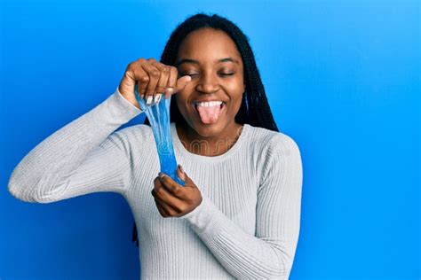 African American Woman With Braided Hair Holding Slime Sticking Tongue