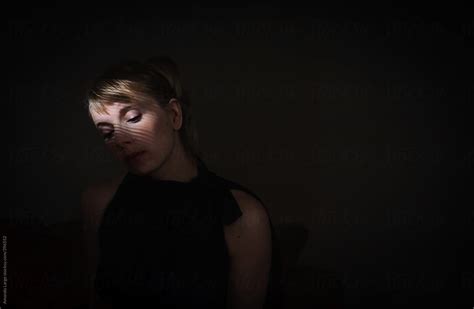 Woman Sitting In A Dark Room With Her Face Partially Lit Del