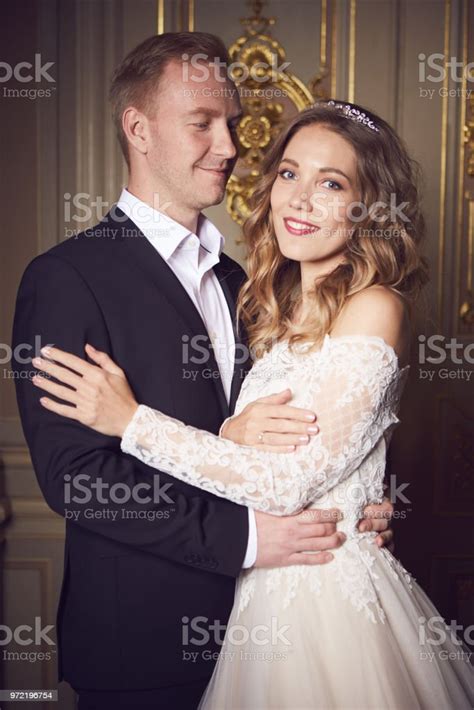 웨딩 커플 실내 서로 포옹 이다 흰색 드레스에 아름 다운 모델 소녀입니다 남자 양복입니다 신랑와의 아름다움 신부 여성 및 남성 초상화입니다 레이스 베일과 여자입니다 귀여운