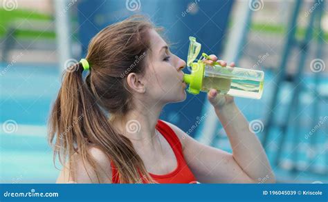 Young Female Athlete Drinking Water After Workout In The Open Air