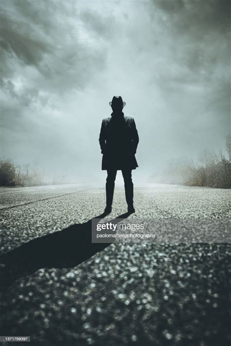 Front View Of Silhouette Gangster Standing On Road High Res Stock Photo