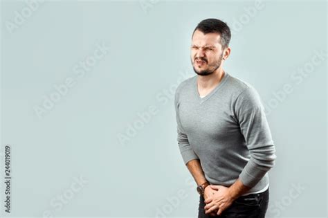 A Young Attractive Man Feels Pain In His Groin Arms Folded Between