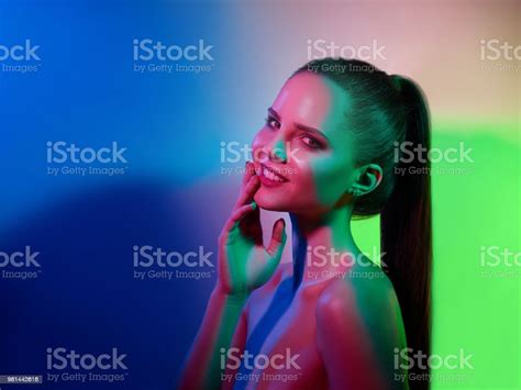 High Fashion Model Woman In Colorful Bright Lights Posing In Studio
