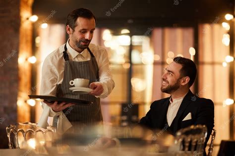 Premium Photo Smiling Waiter Bringing Coffee To Guest In Restaurant