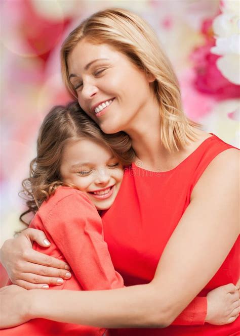 Happy Mother And Daughter Hugging And Smiling At Camera Stock Photo