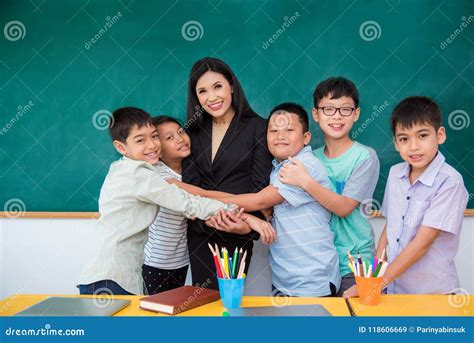 Student Hugging Their Teacher In Classroom Stock Image Image Of