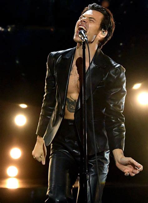 A Man In Leather Pants Singing Into A Microphone