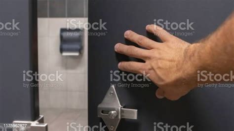 Close Up Of Tan Hairy Man Hand Pushing Open A Bathroom Stall Stock