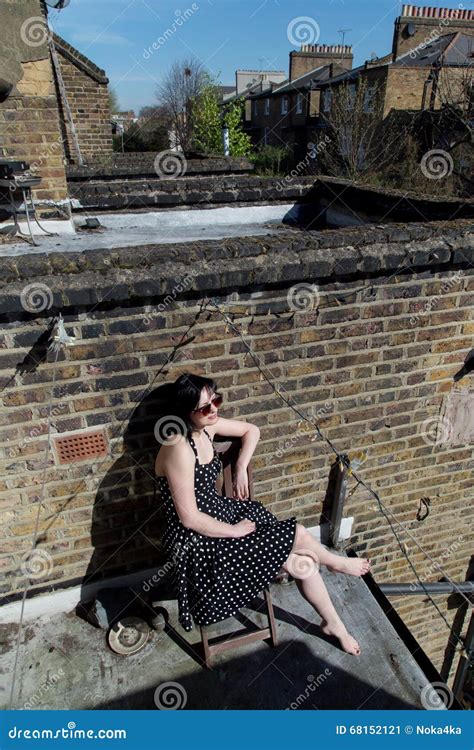 Girl In Black Polka Dot Dress Sitting On The Balcony Stock Image